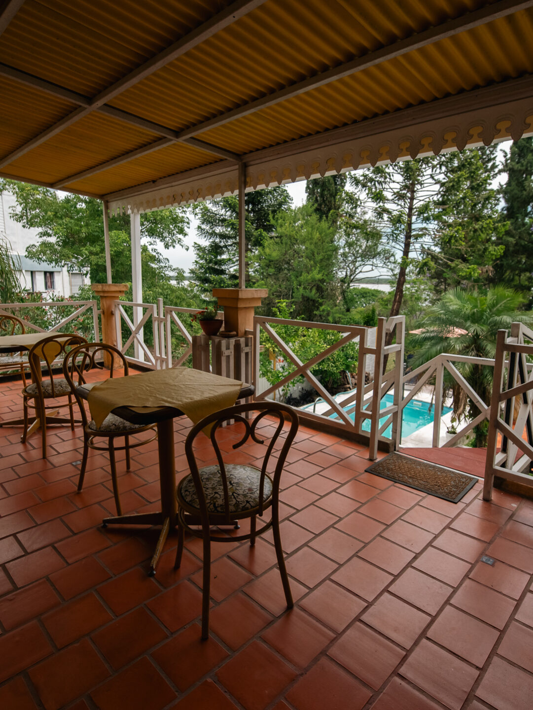 Galería techada en Le Village Villa Urquiza entre rios con mesa y sillas para disfrutar al aire libre.