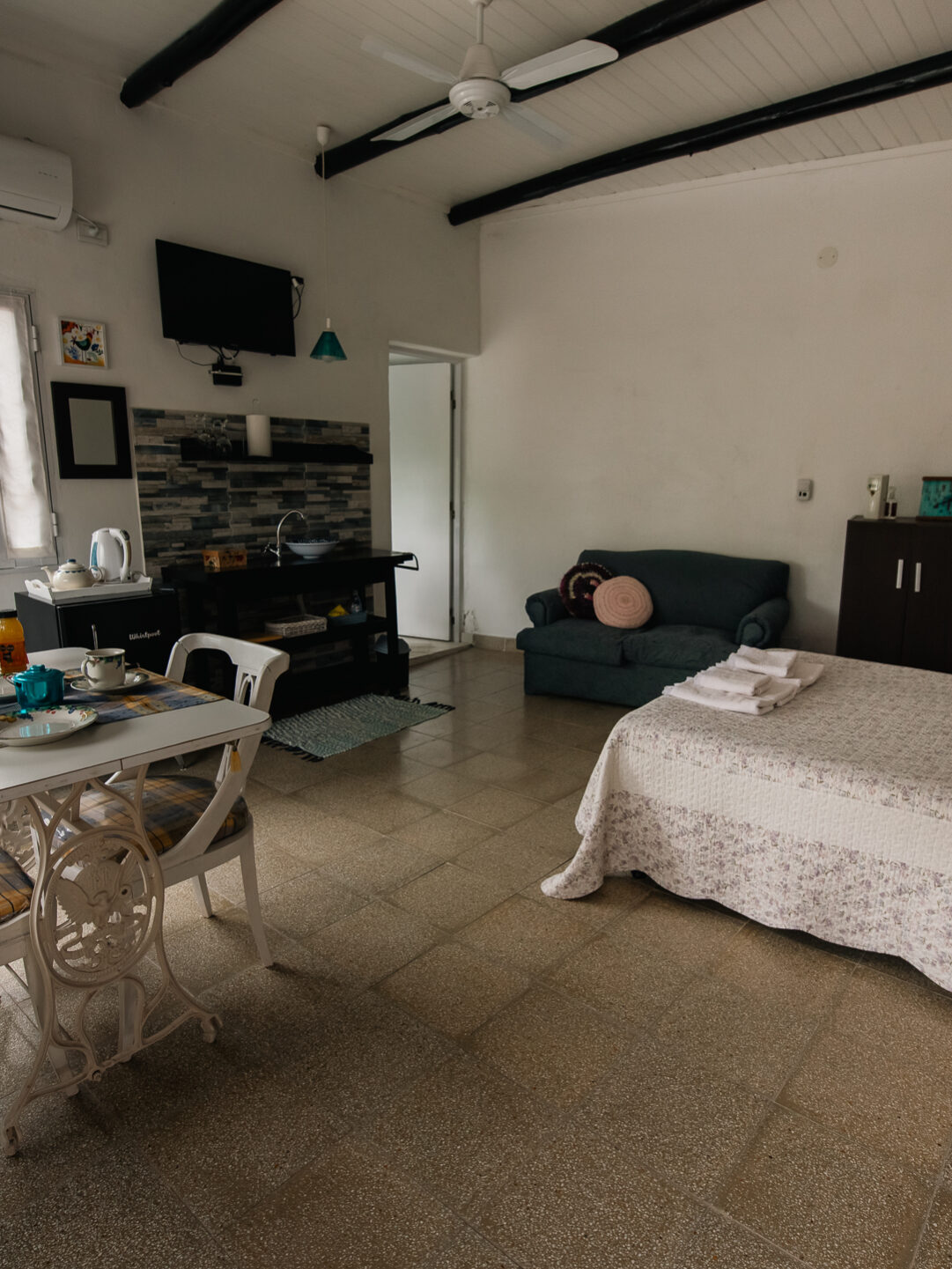 Sala de estar y cocina integrada en Le Village Villa Urquiza, alojamiento cómodo y equipado para parejas.