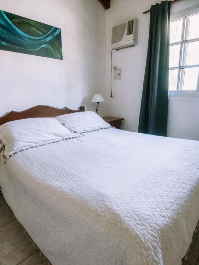 Cabaña en Casas de Campo Villa Urquiza con cama matrimonial, aire acondicionado y vista al jardín.