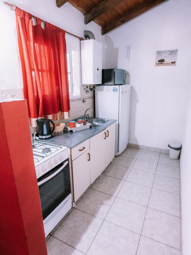 Cocina completa en Casas de Campo Villa Urquiza con heladera, mesada y utensilios básicos para estadías familiares