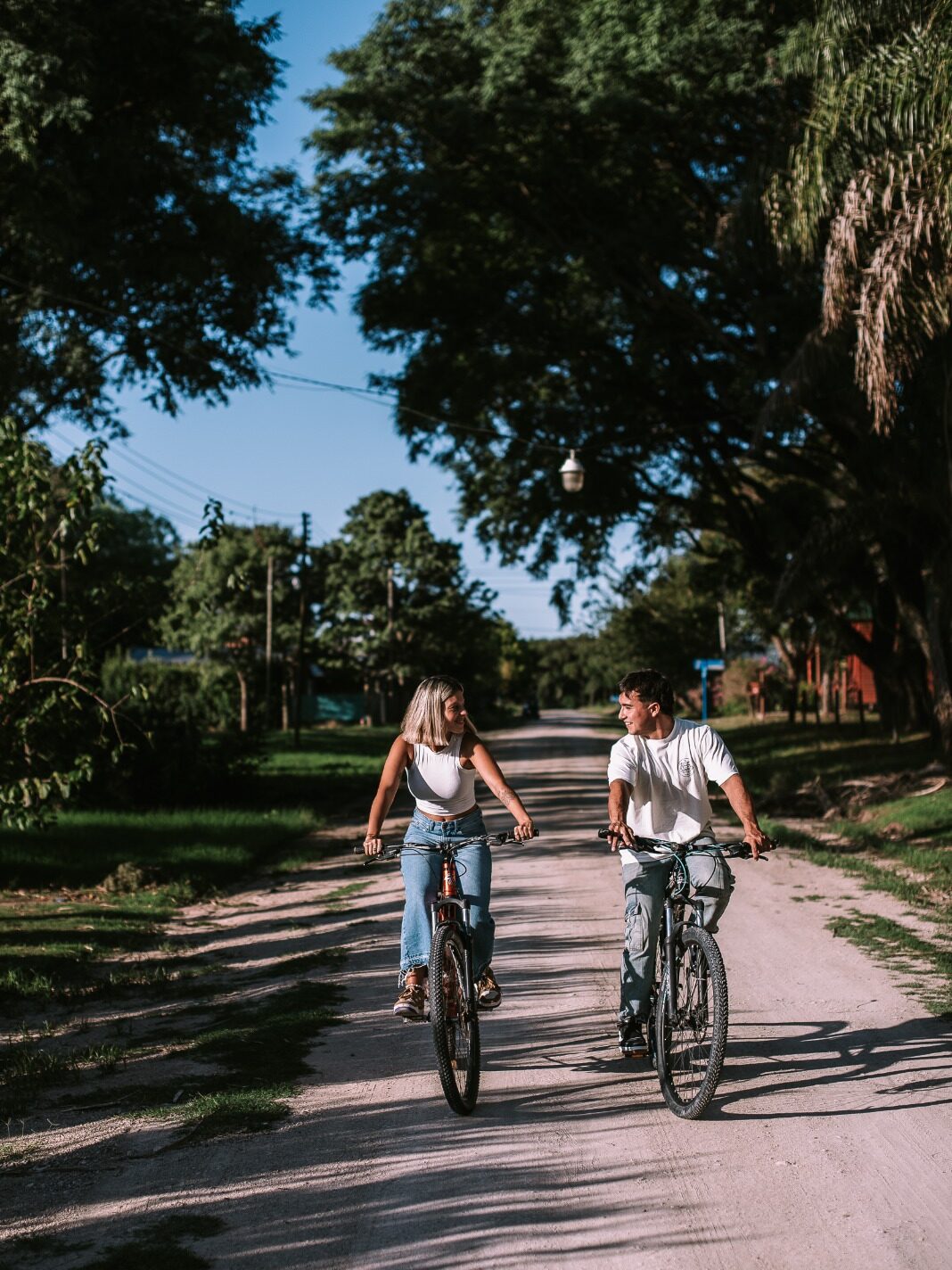 Pareja andando en bicicleta entre árboles — Escapada Romántica en Villa Urquiza, Entre Ríos