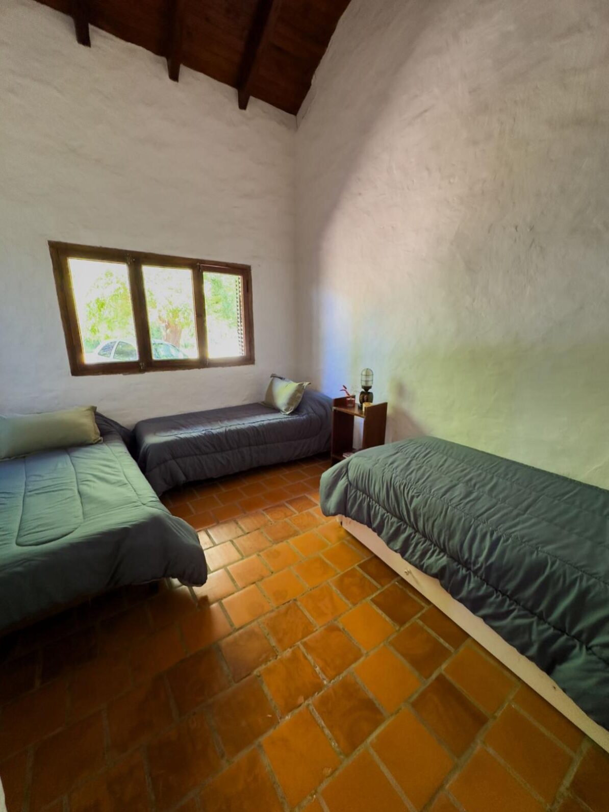 Habitación con dos camas individuales y ventana al exterior en Quinta Vista al Río, Villa Urquiza, Entre Ríos.