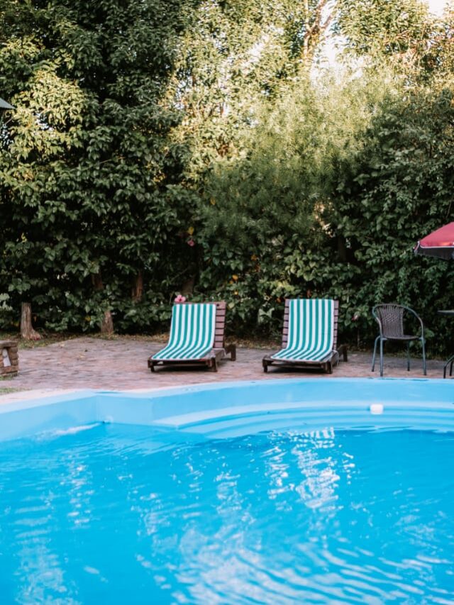 Piscina del complejo Casas de Campo Villa Urquiza, rodeada de árboles y césped, perfecta para disfrutar en familia o con amigos