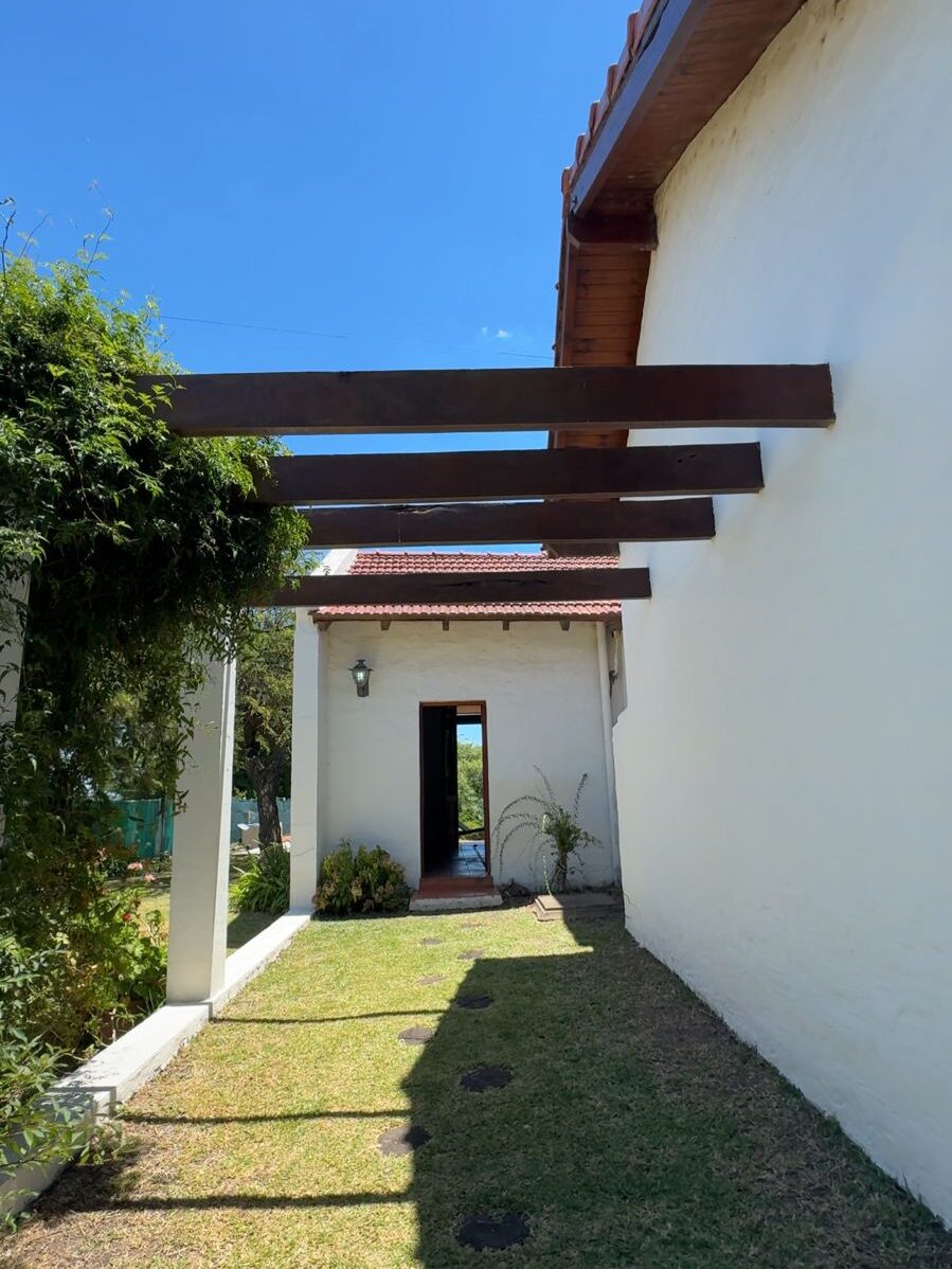 Entrada de la casa con pérgola de madera y parque verde en Quinta Vista al Río, Villa Urquiza, Entre Ríos