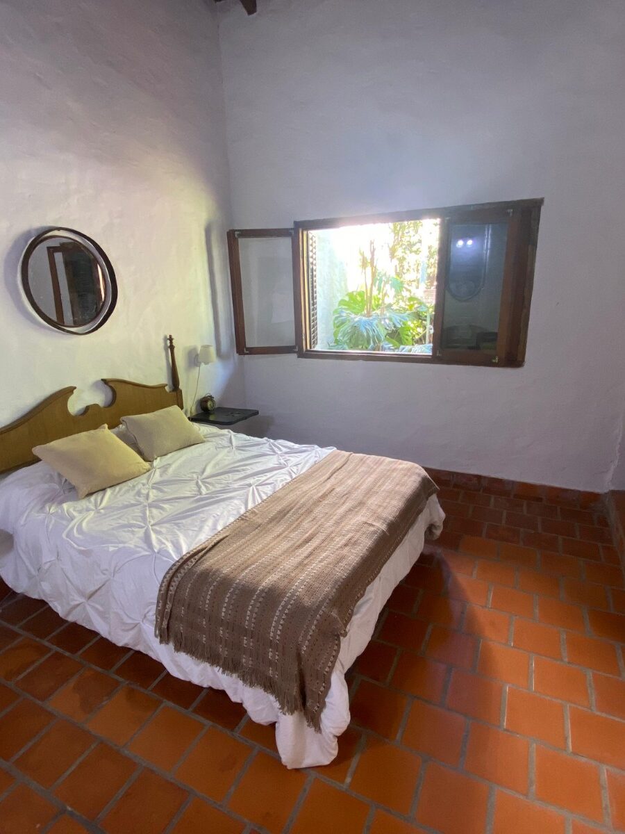 Habitación con cama matrimonial y ventana al parque en Quinta Vista al Río, Villa Urquiza, Entre Ríos