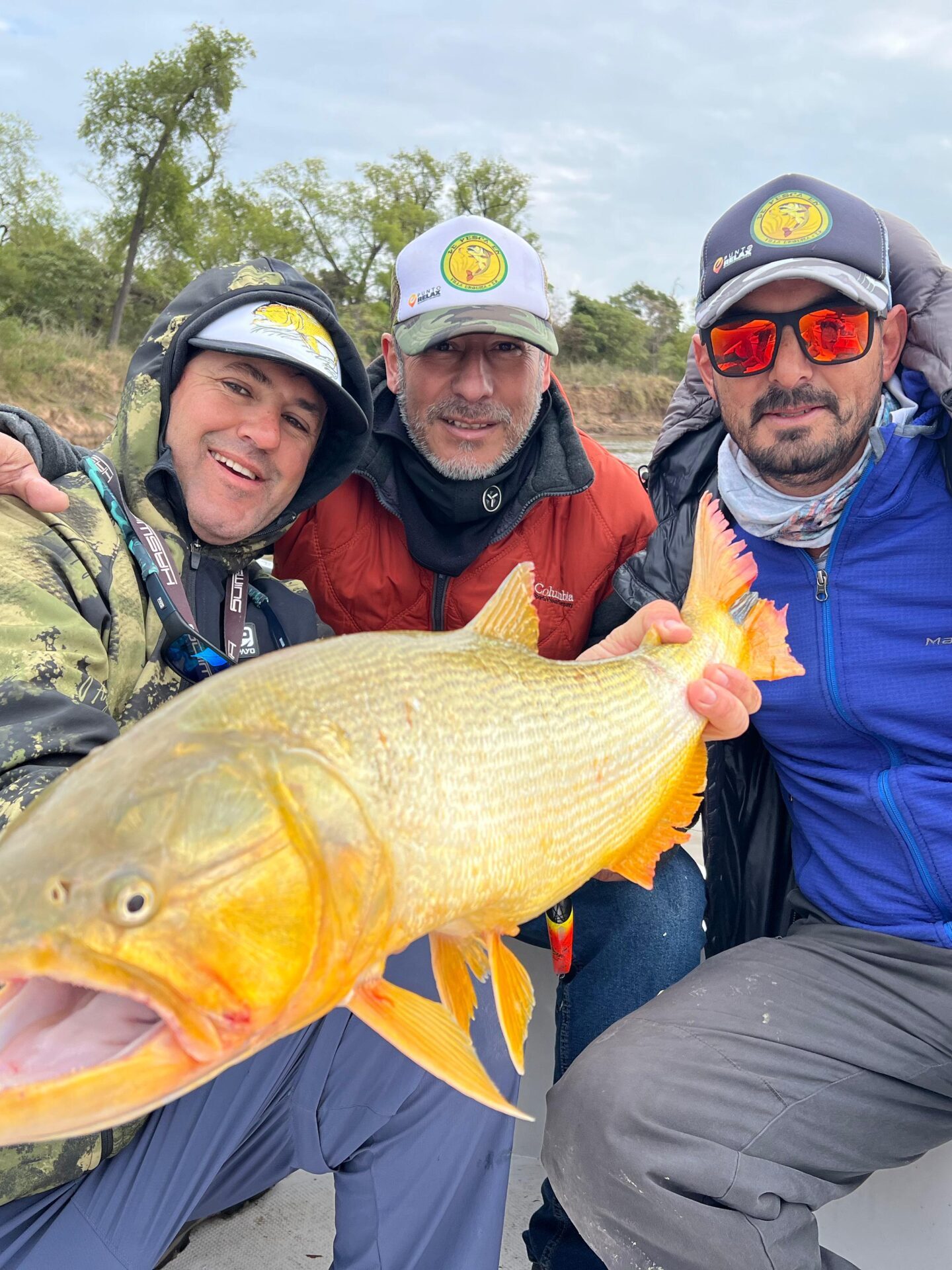 Cliente de Punto Relax sosteniendo un gran dorado dorado durante una excursión de pesca deportiva en Entre Ríos